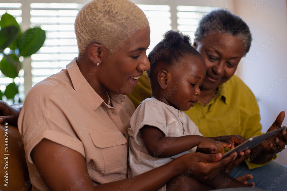 Three generations of a family looking at a tablet together